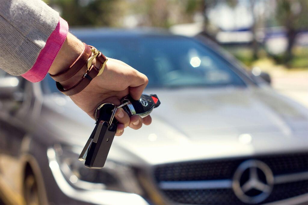 an image of car keys with a car behind showing Car rental is another option when going to hakuba.